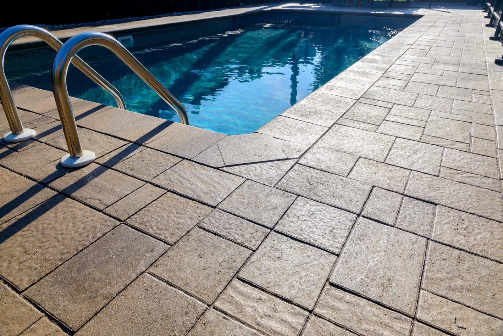 A screened in porch with a swimming pool in the background