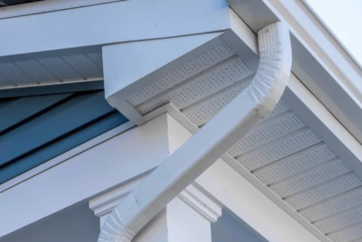 A close up of a gutter on the roof of a house.