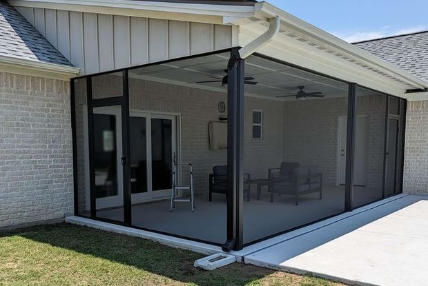 There is a swimming pool in the backyard with a screened in area.