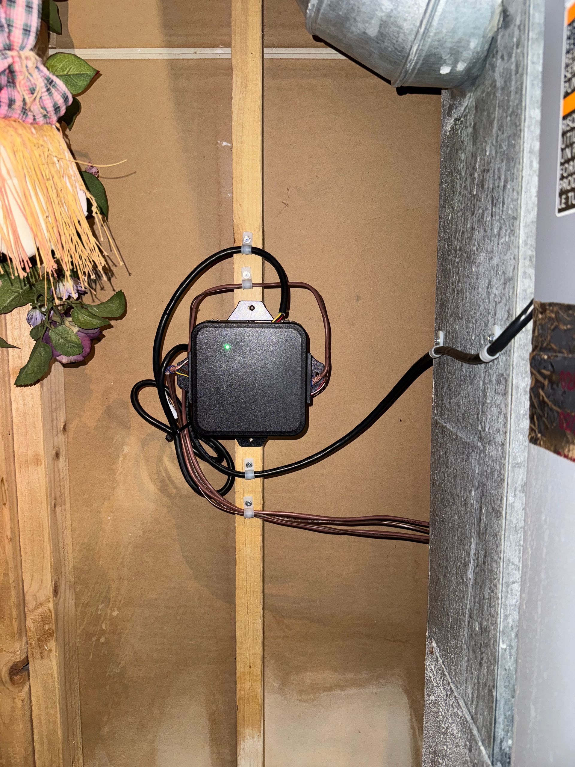 Black box with wires attached to a wall, possibly electrical.