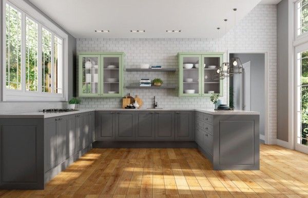 Una cocina con gabinetes grises y gabinetes verdes y piso de madera.