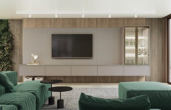 Una sala de estar con muebles verdes y un televisor de pantalla plana.