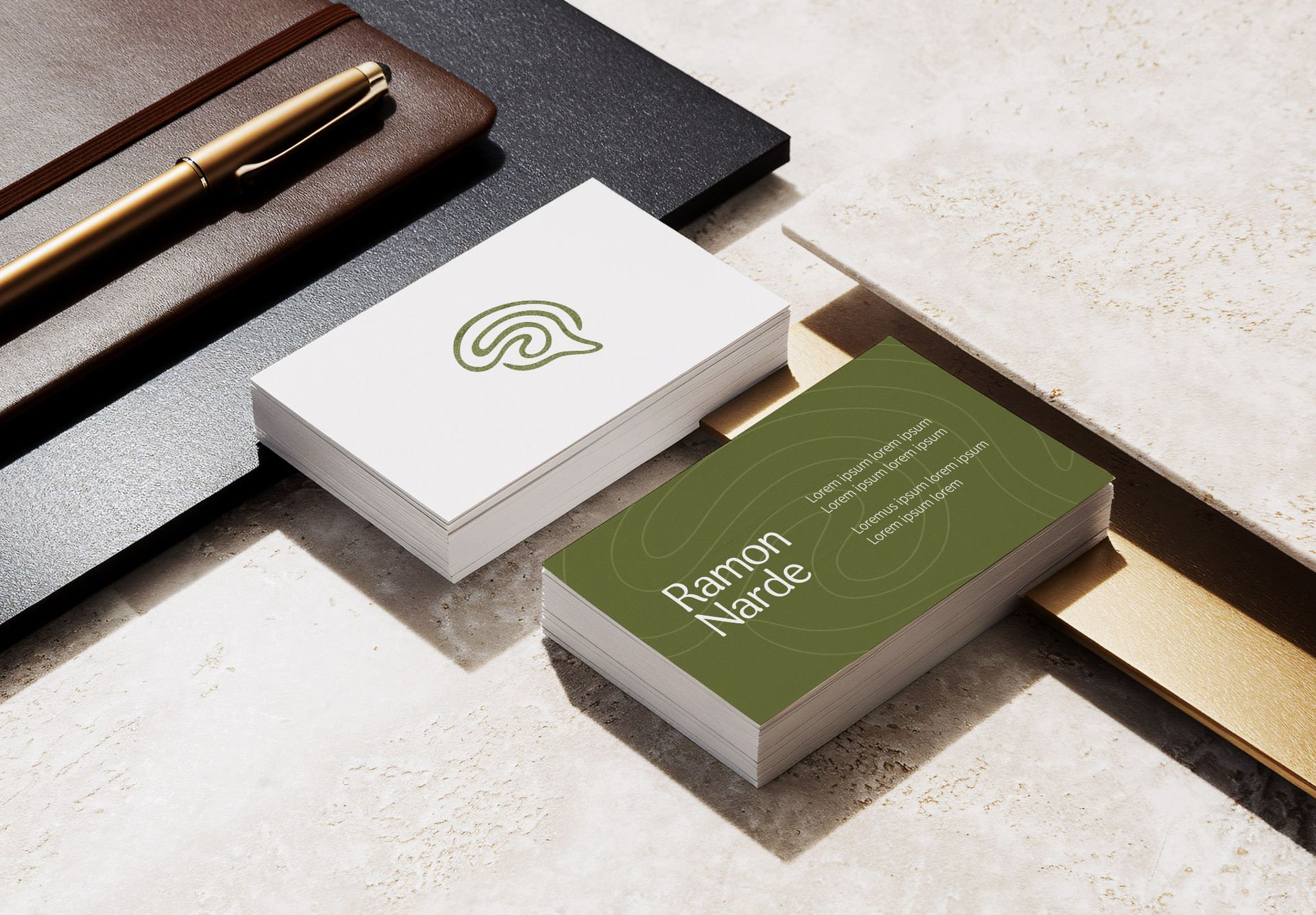 Dois cartões de visita em couro marrom; um branco com logotipo, um azul marinho com texto.