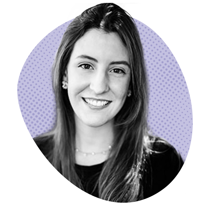 Mulher sorridente com longos cabelos castanhos, usando brincos e um colar, sobre um fundo roxo estampado.