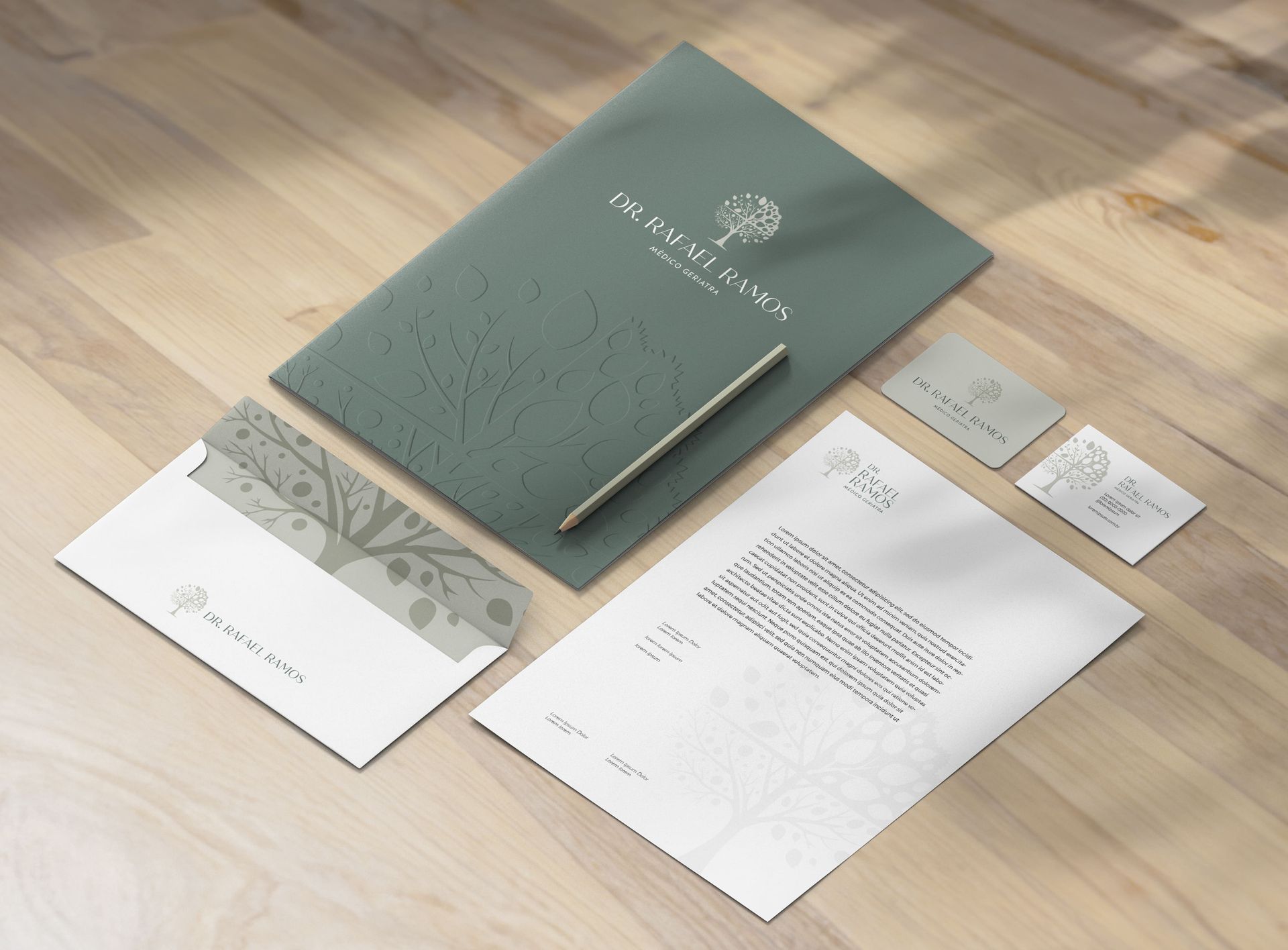 Conjunto de papelaria em madeira: papel timbrado, envelope, cartões de visita, pasta e caneta em tons de azul e branco.