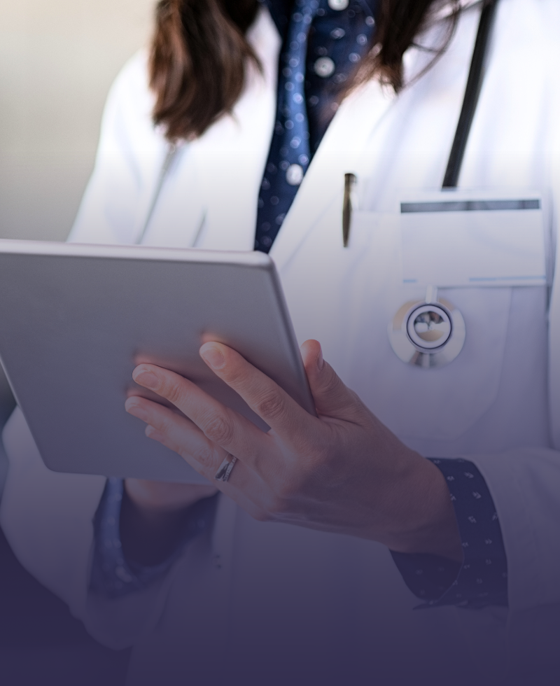 Uma mulher de jaleco está usando um tablet