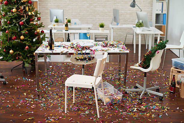 Desk by the Christmas tree with confetti and decorations all over the floor in a mess