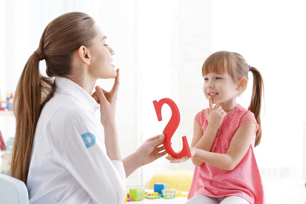 Una donna insegna a una bambina come parlare con una lettera rossa.