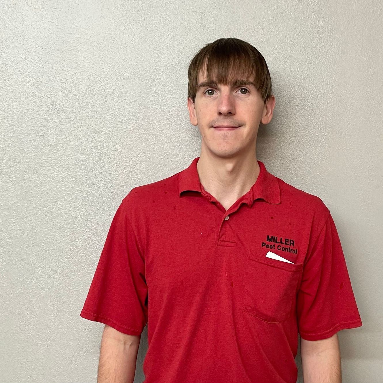 A man wearing a red miller duct company polo shirt