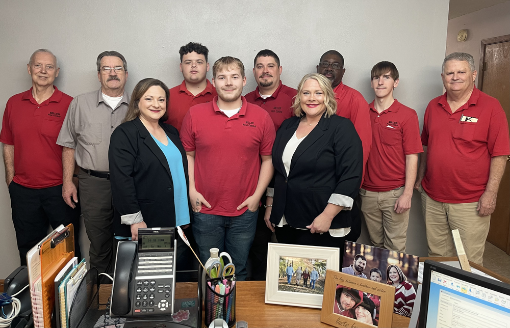 A group of people in red shirts are posing for a picture in an office.