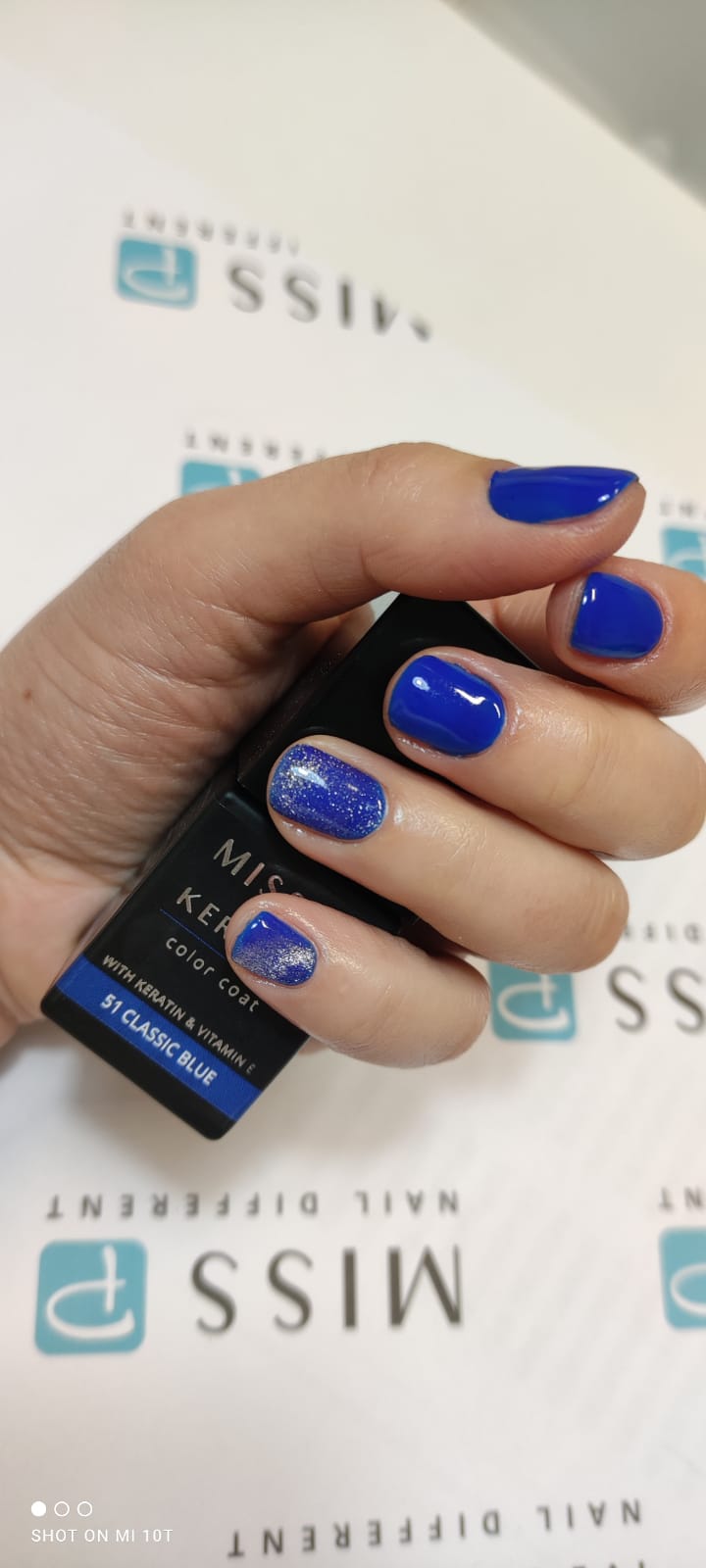 manicure con smalto blu elettrico e brillantini