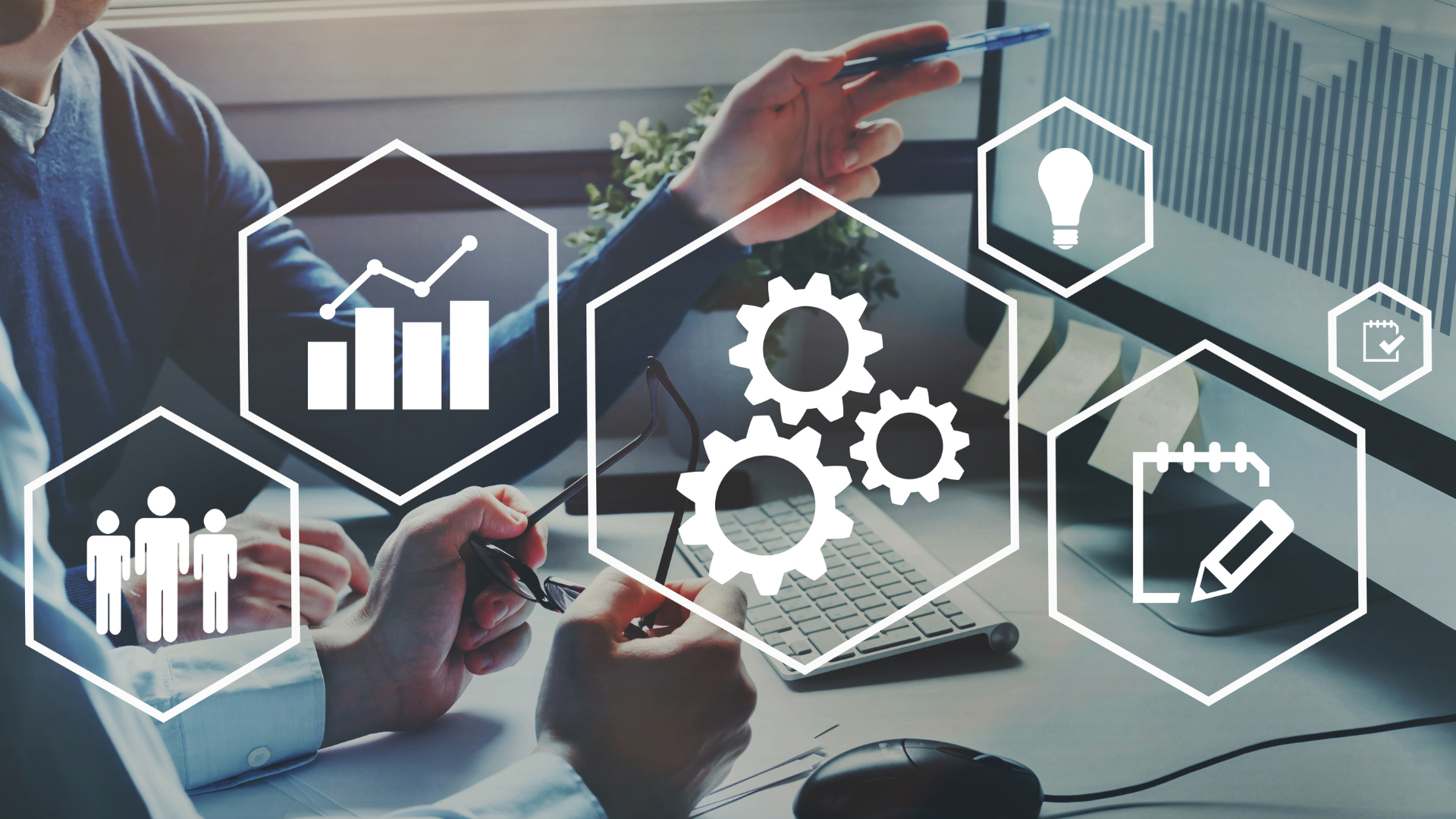 A group of people are sitting at a desk looking at a computer screen.