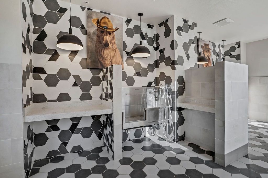 Shared communal shower area with black-and-white hex tile walls and concrete benches.
