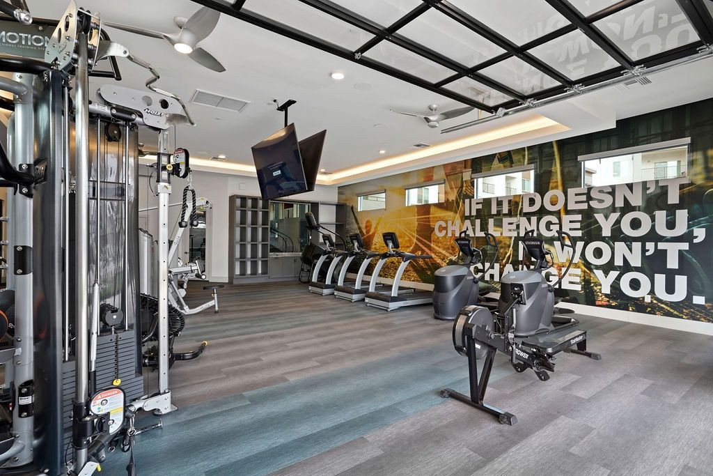 Interior view of a modern fitness center with cardio machines and weight equipment.