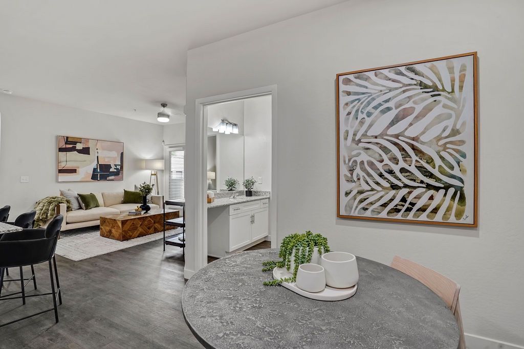 Open-concept living space with dining table in the foreground and a kitchen in the background.