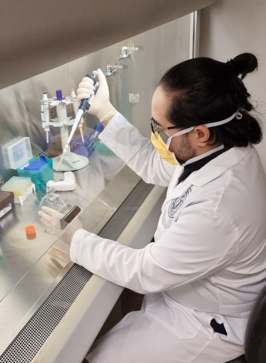 A man in a lab coat is using a pipette