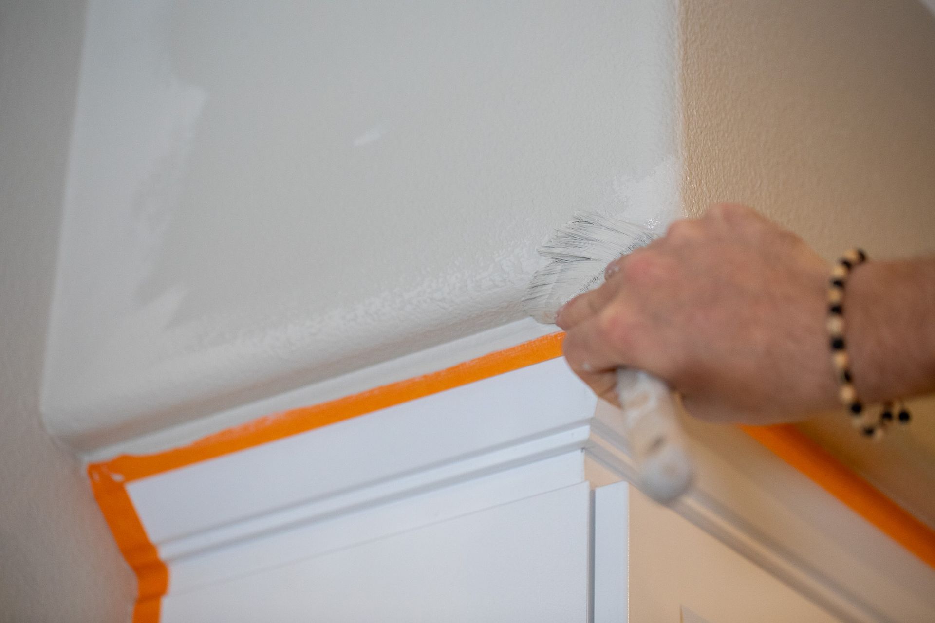 A person is painting a wall with a brush.