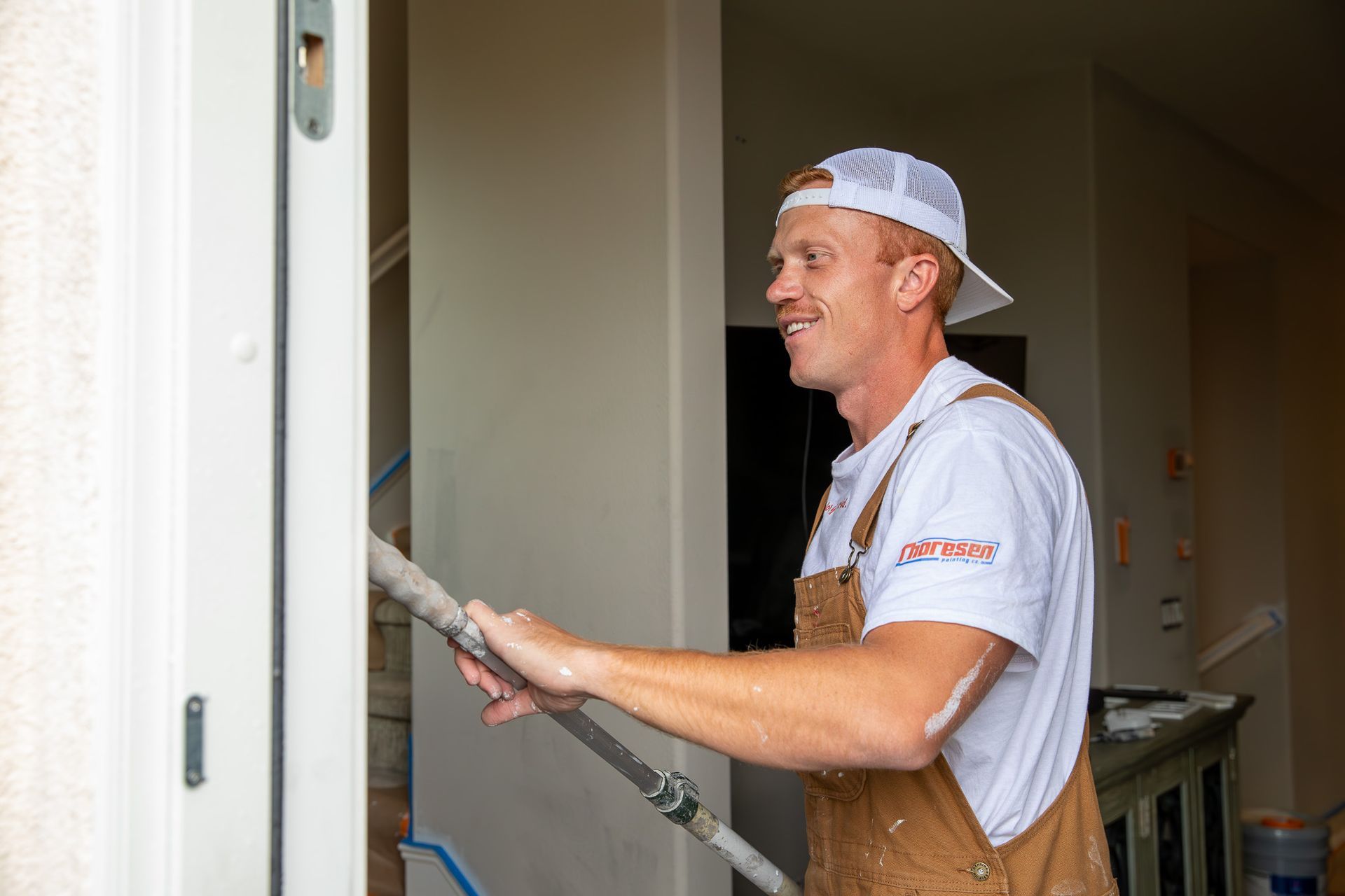 A man is painting a door with a paint roller.