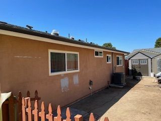 The back of a house with a fence and a garage.