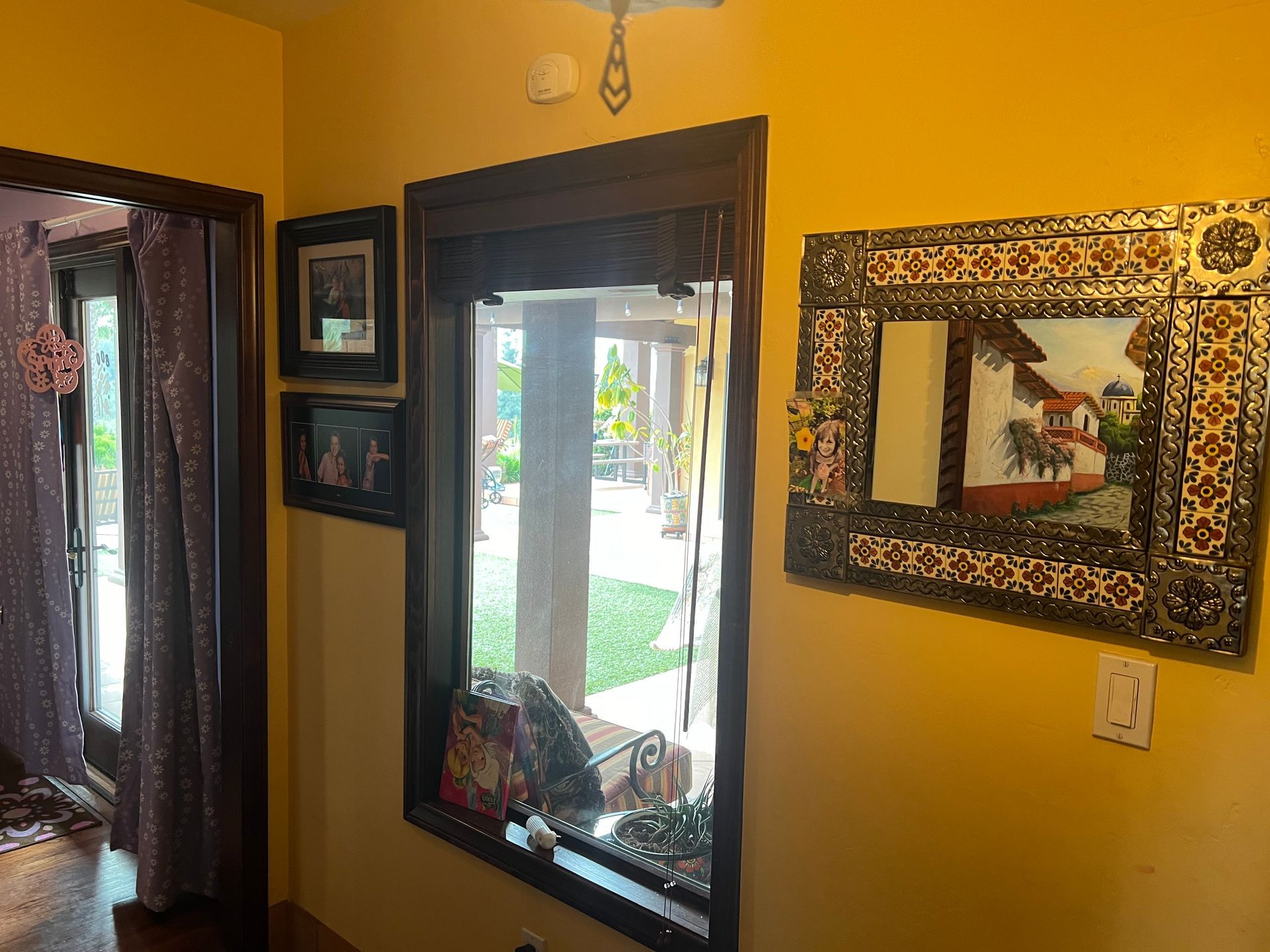 A room with a large mirror and a picture on the wall.