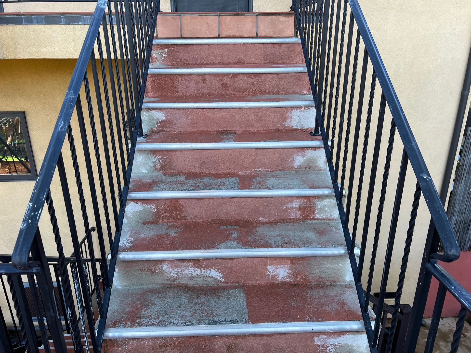 A set of stairs leading up to a building with a wrought iron railing