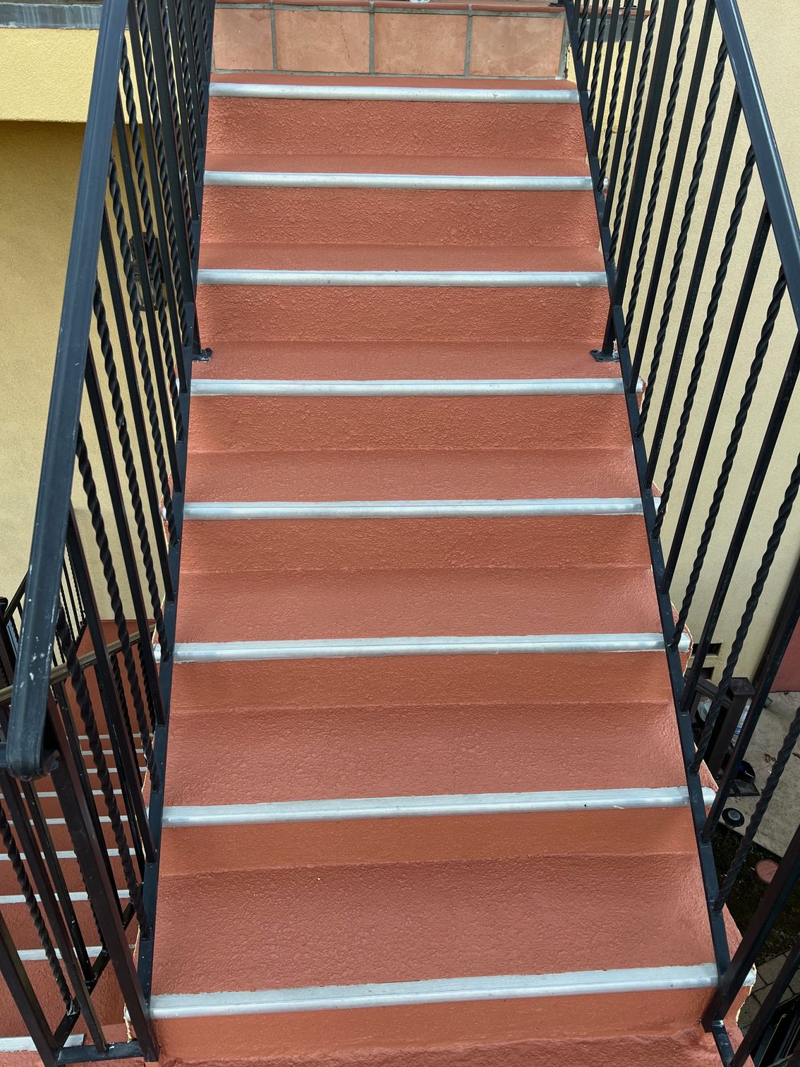 A set of stairs leading up to a balcony with a metal railing.