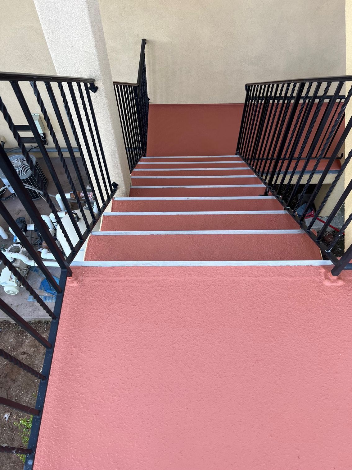 A set of stairs leading up to a balcony with a metal railing.