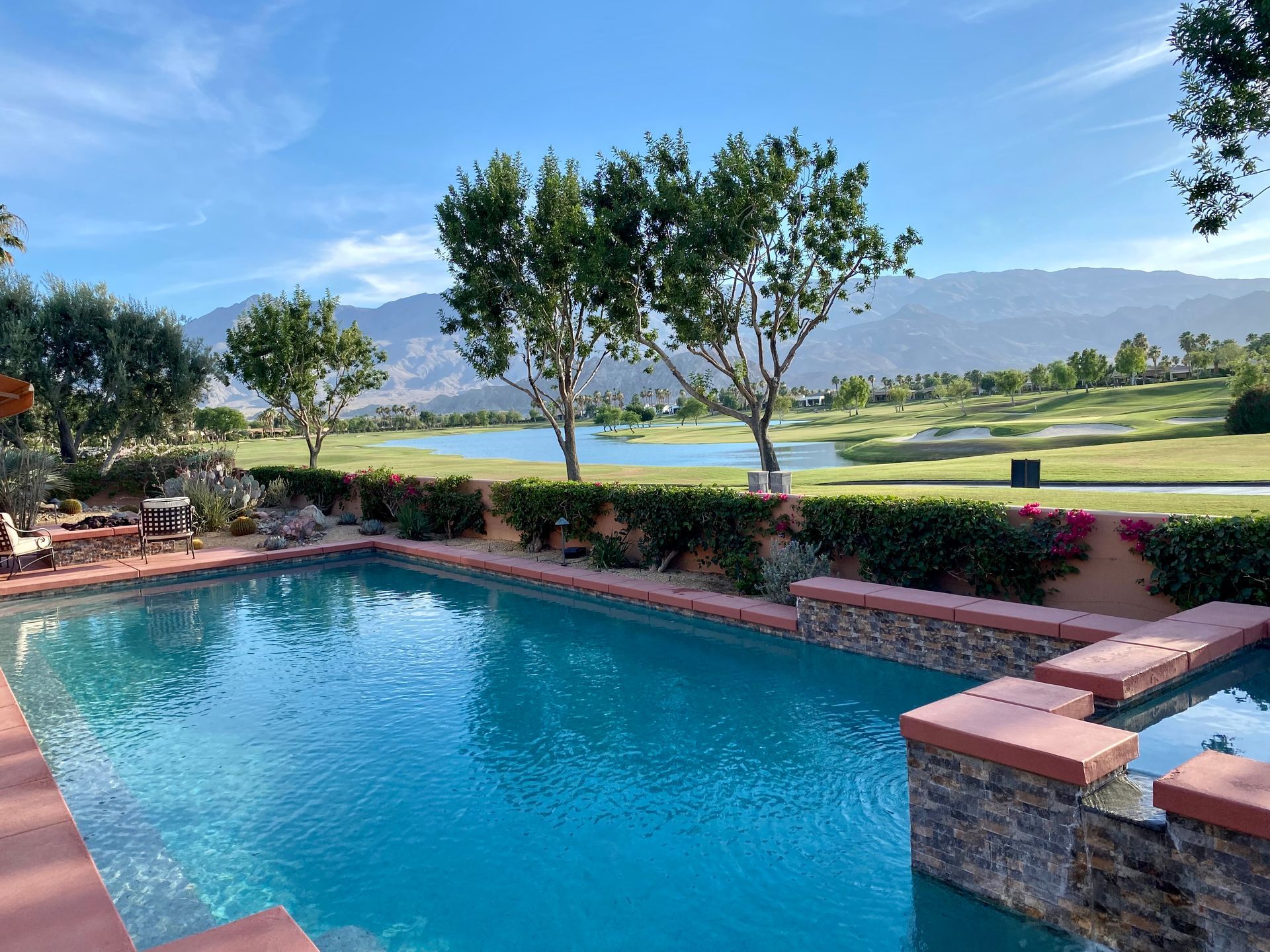 A large swimming pool with a view of a golf course