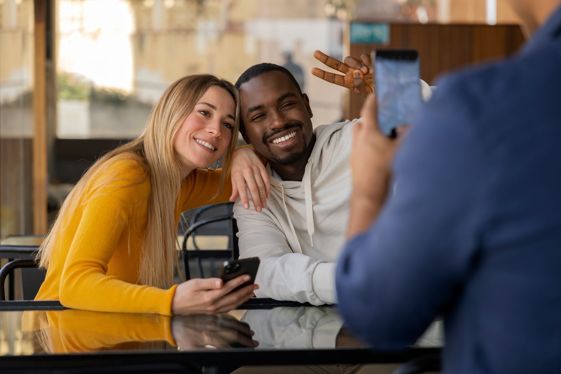 A man is taking a picture of a man and woman sitting at a table.