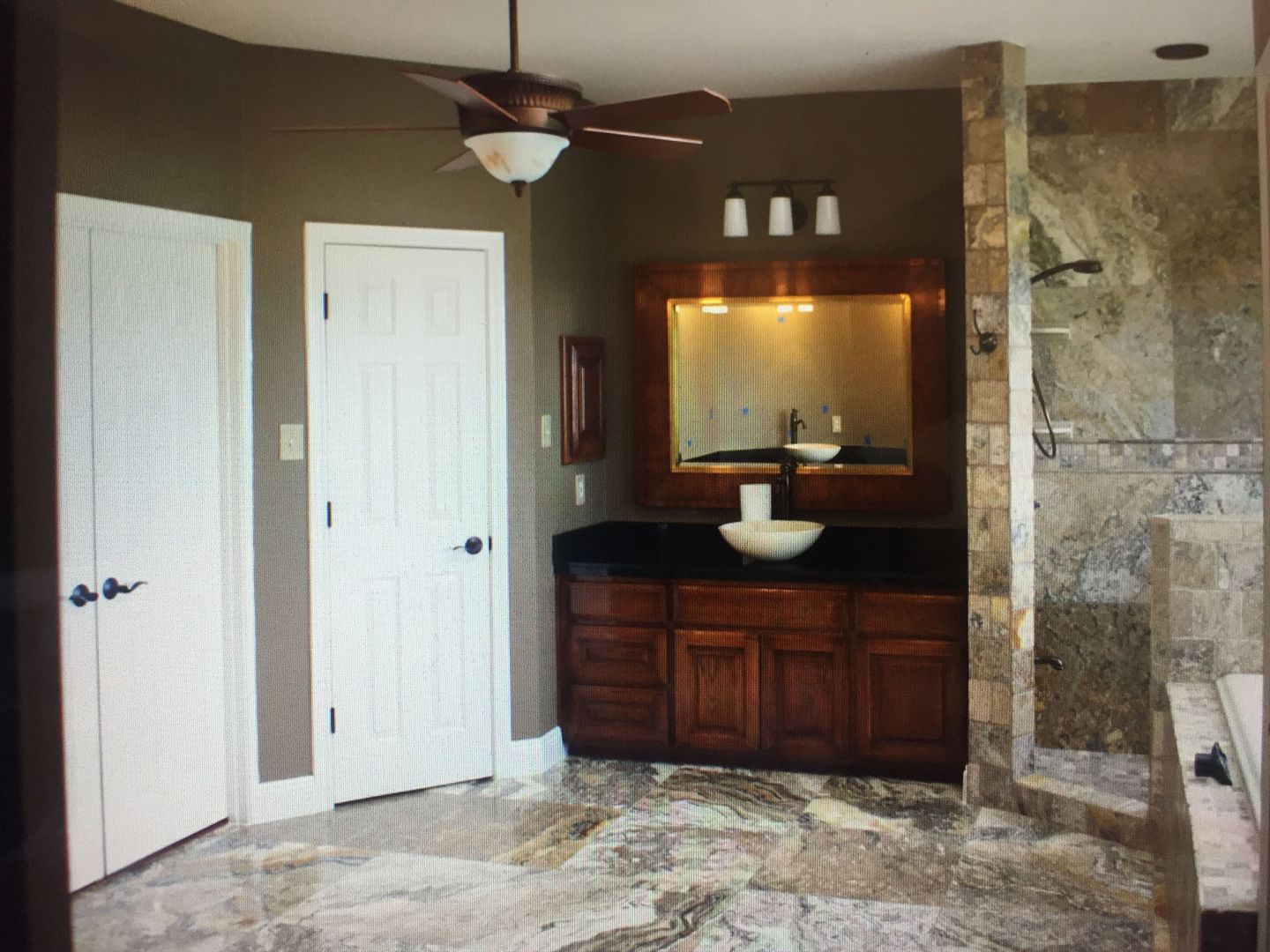 A bathroom with a sink a mirror and a ceiling fan