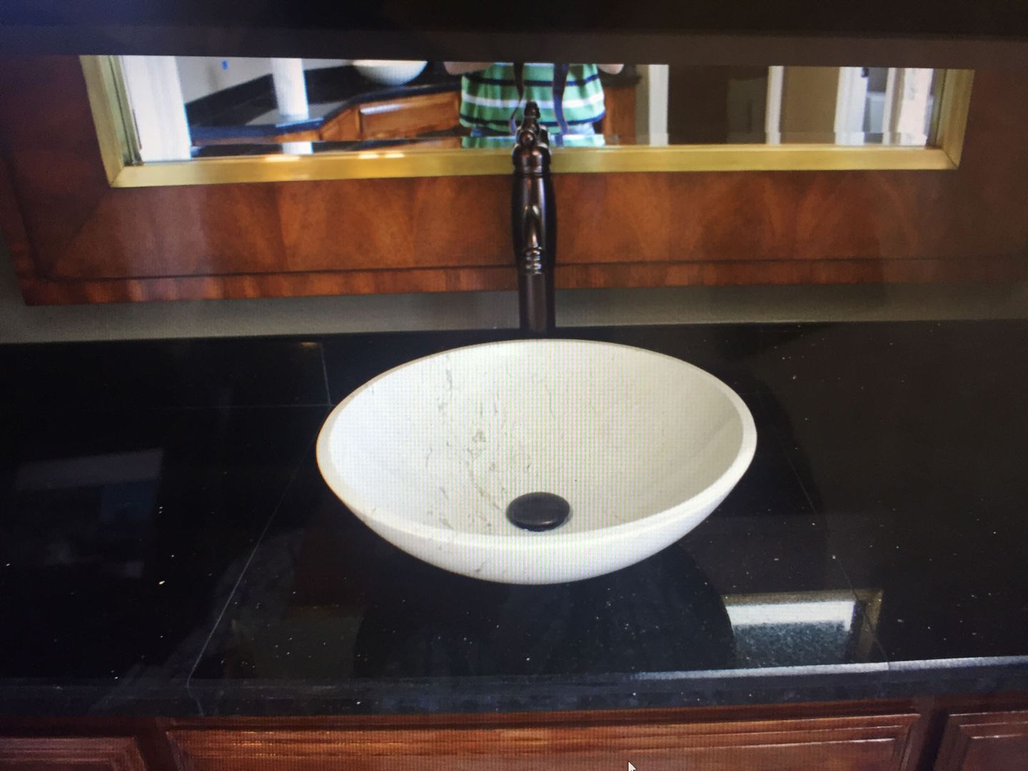 A bathroom sink with a black counter top