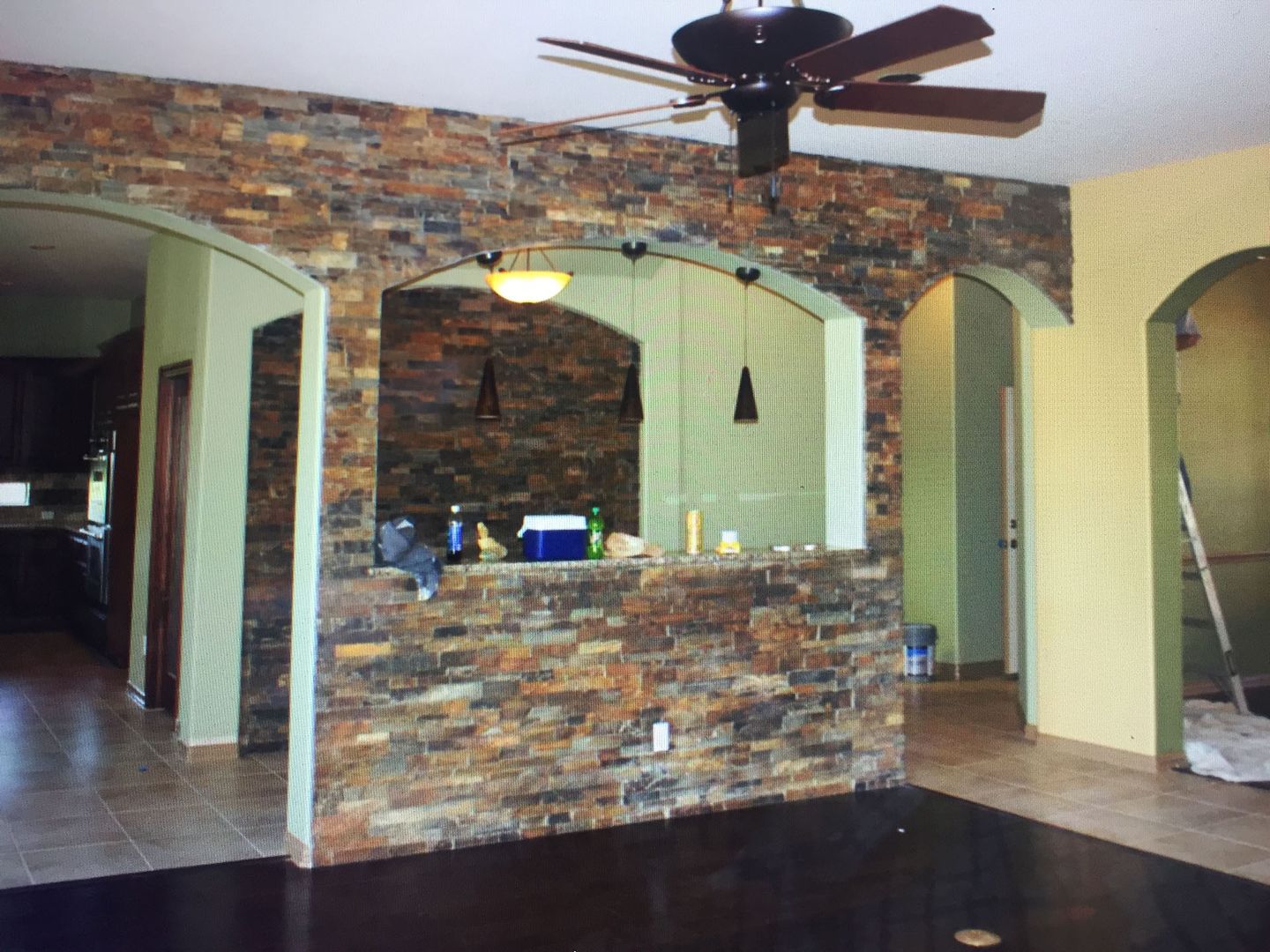 A room with a stone wall and a ceiling fan