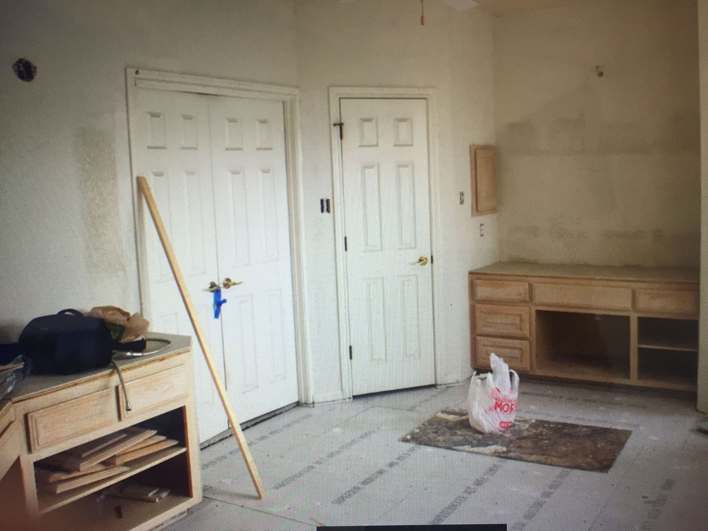 A room with a wooden cabinet and a bag on the floor