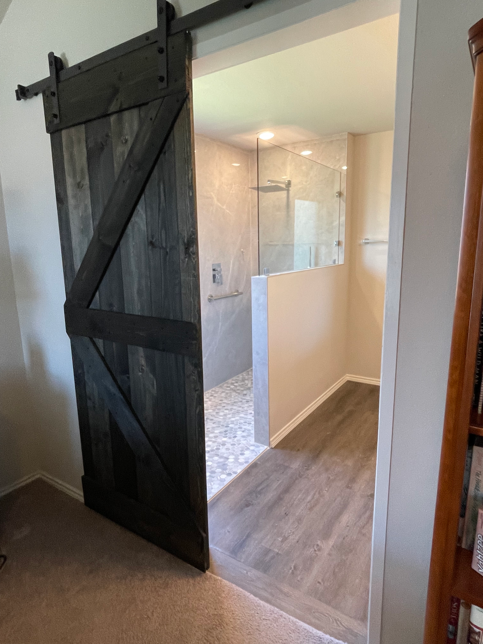 A sliding barn door is open to a bathroom.