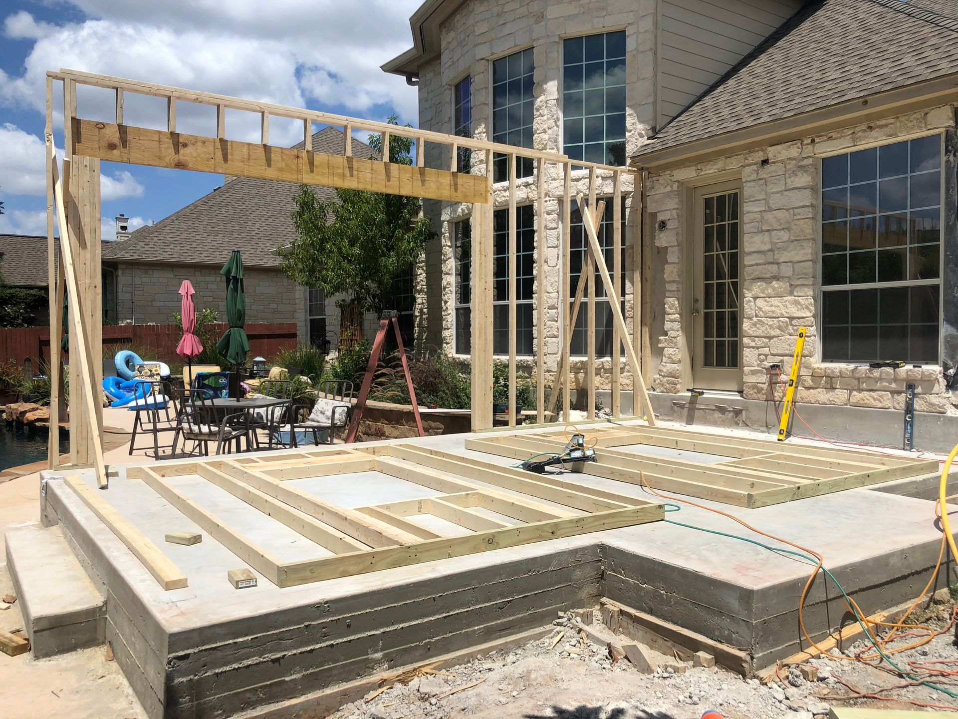 A wooden deck is being built in front of a house.