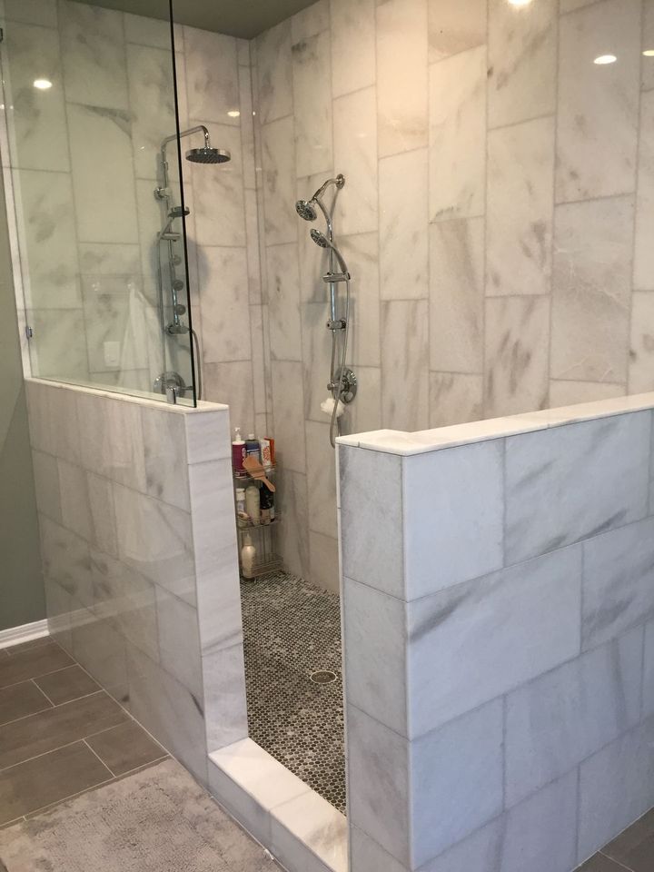 A bathroom with marble tiles and a walk in shower.