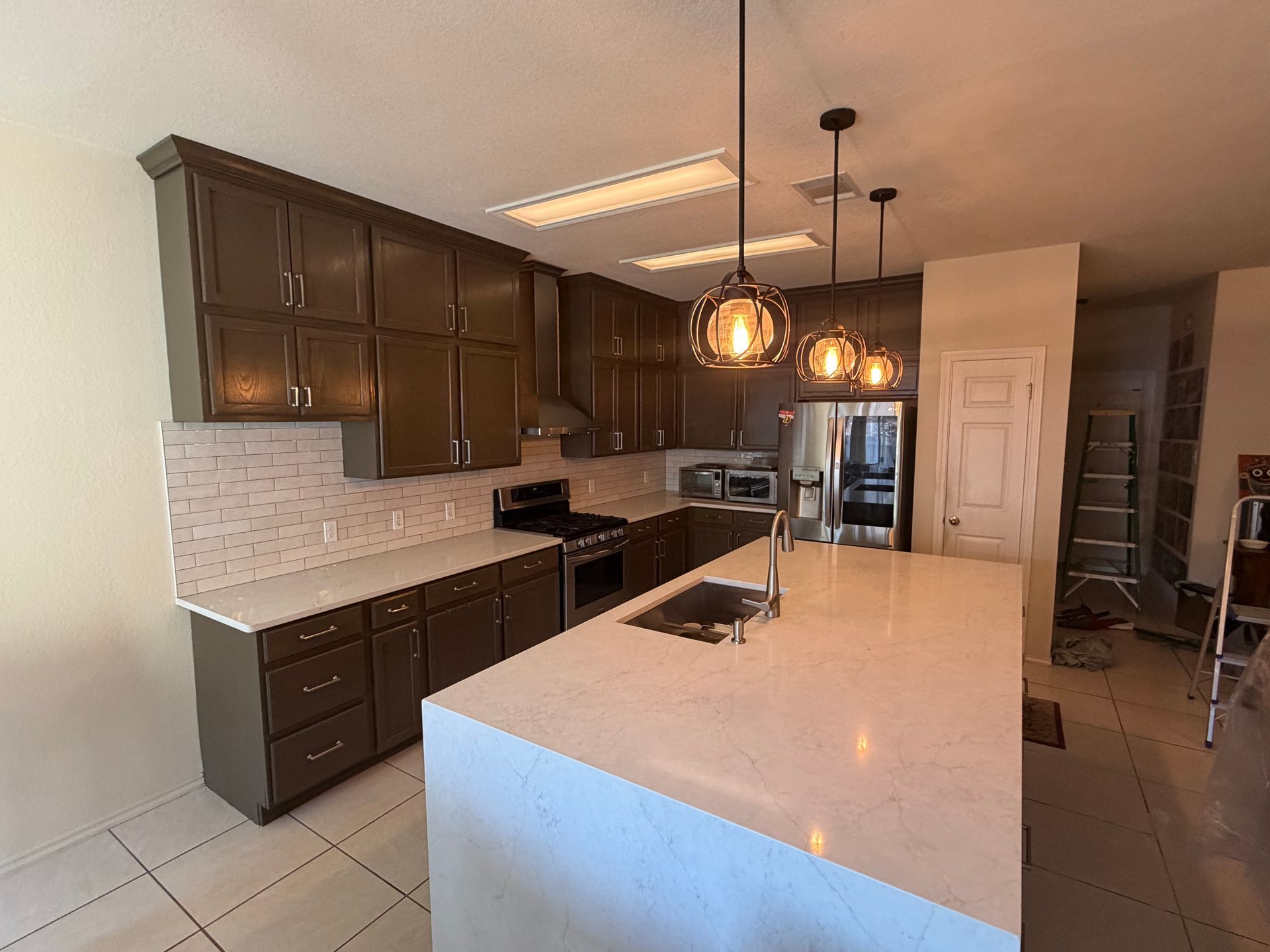 A kitchen with gray cabinets and stainless steel appliances