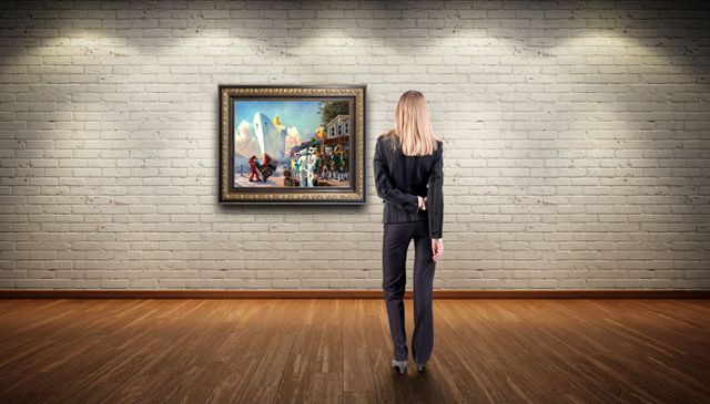 A person stands in a gallery, viewing a landscape painting hanging on a white brick wall above a wooden floor.