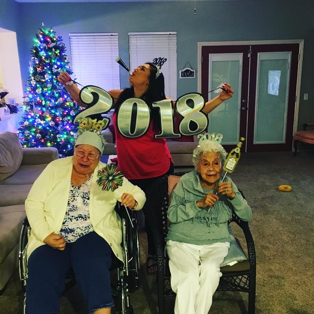 Three women are posing for a picture with a sign that says 2018