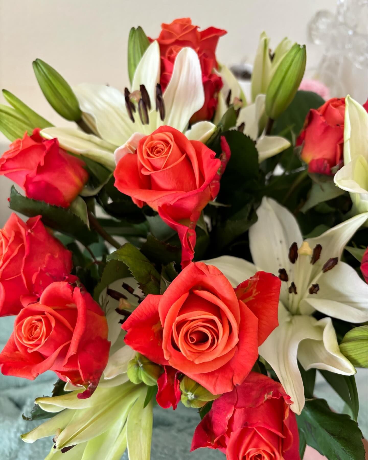 A bouquet of red roses and white lilies on a table