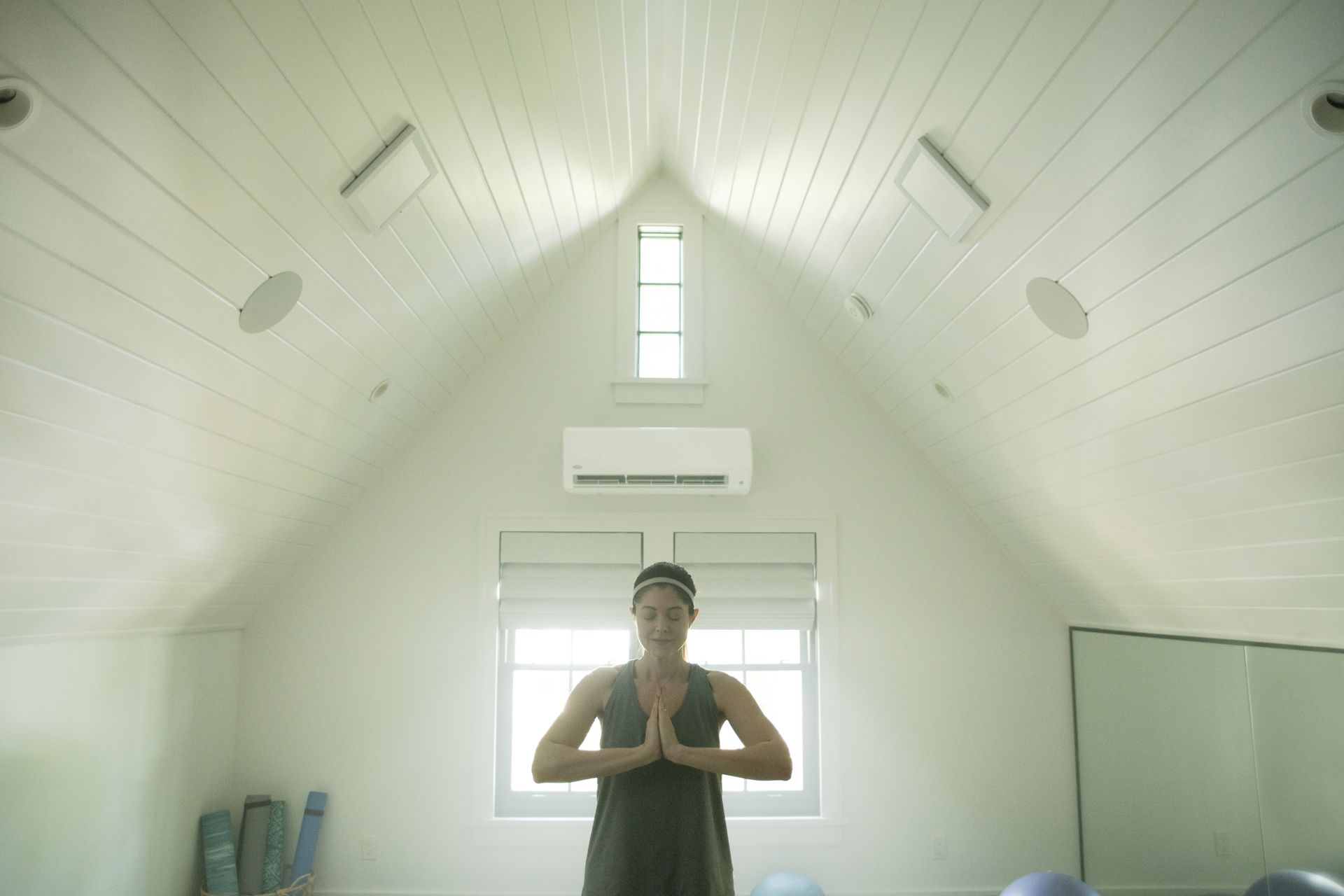 A woman is standing in a room with a vaulted ceiling.