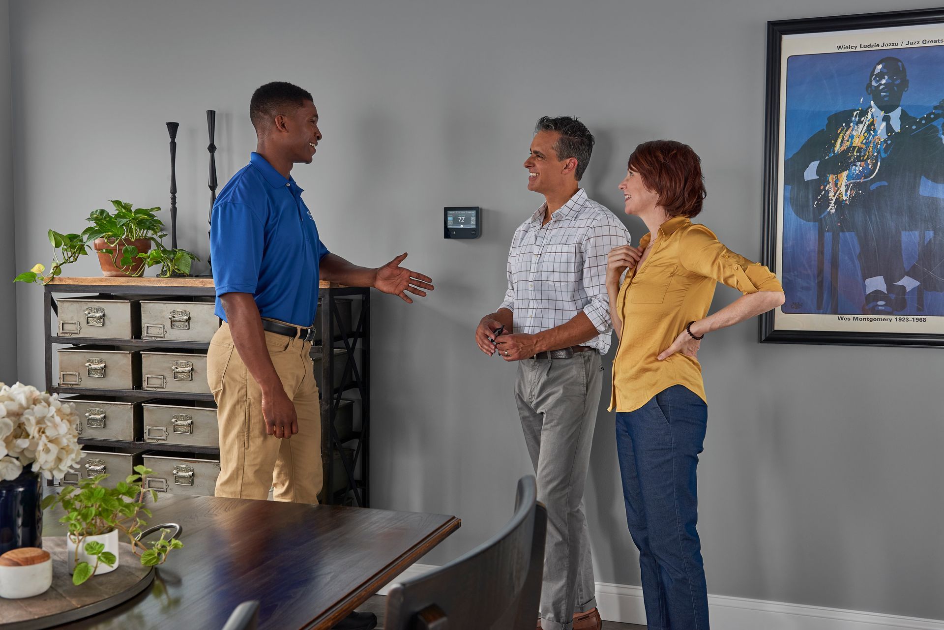 A man is talking to a woman and a man in a living room.