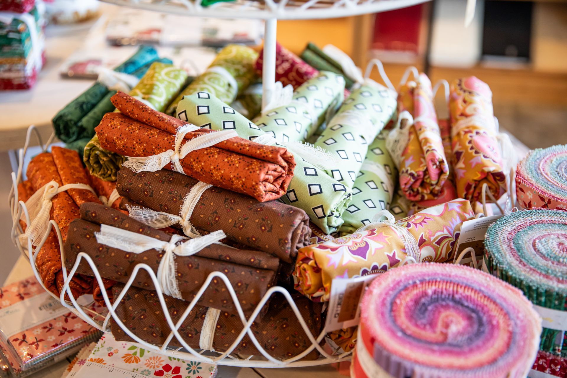 A basket filled with rolls of fabric is sitting on a table.