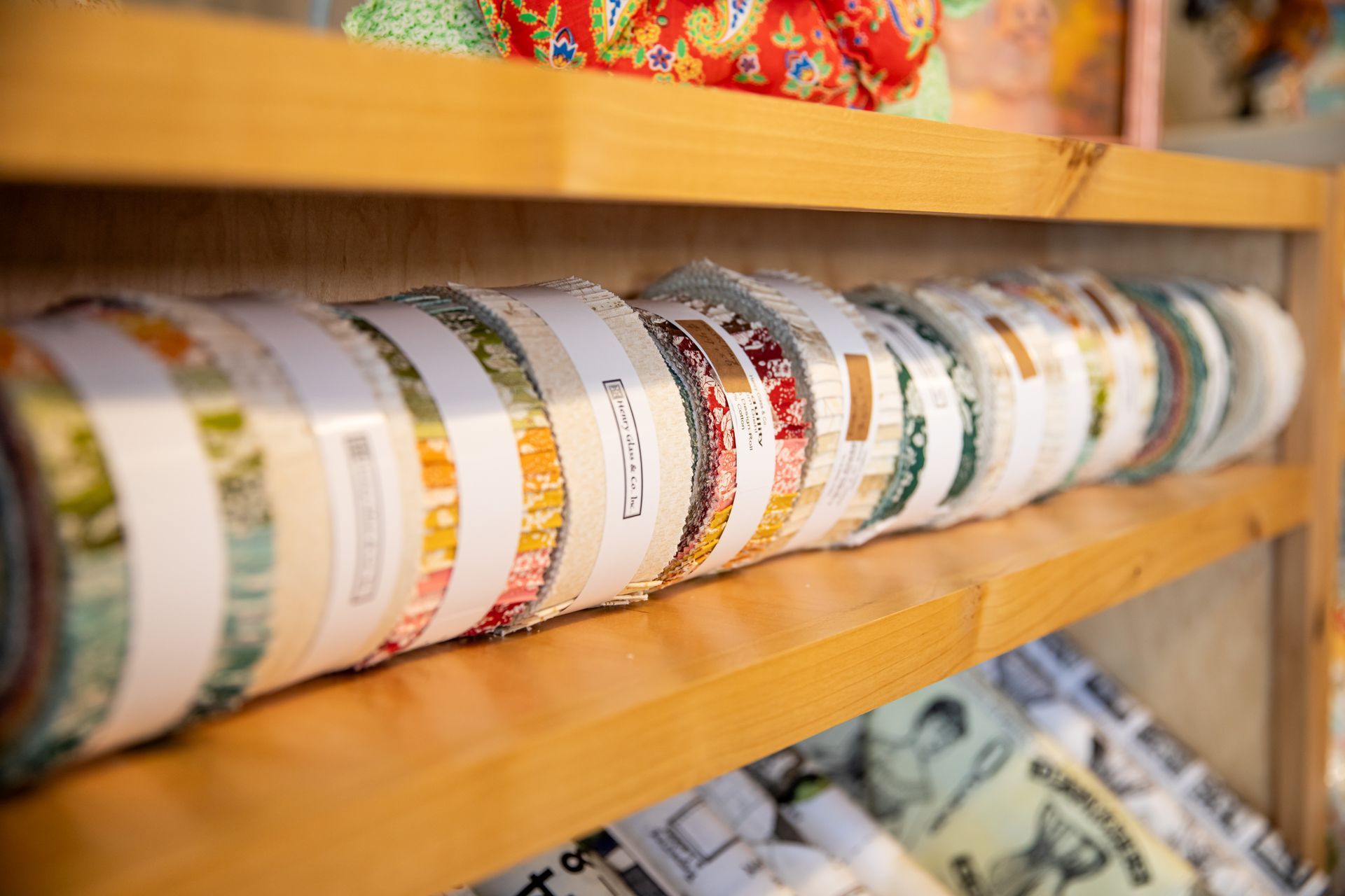 A wooden shelf filled with rolls of ribbon.