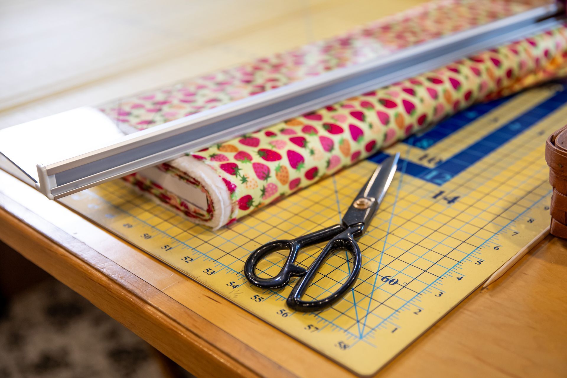 A pair of scissors sitting on top of a cutting mat next to a piece of fabric.