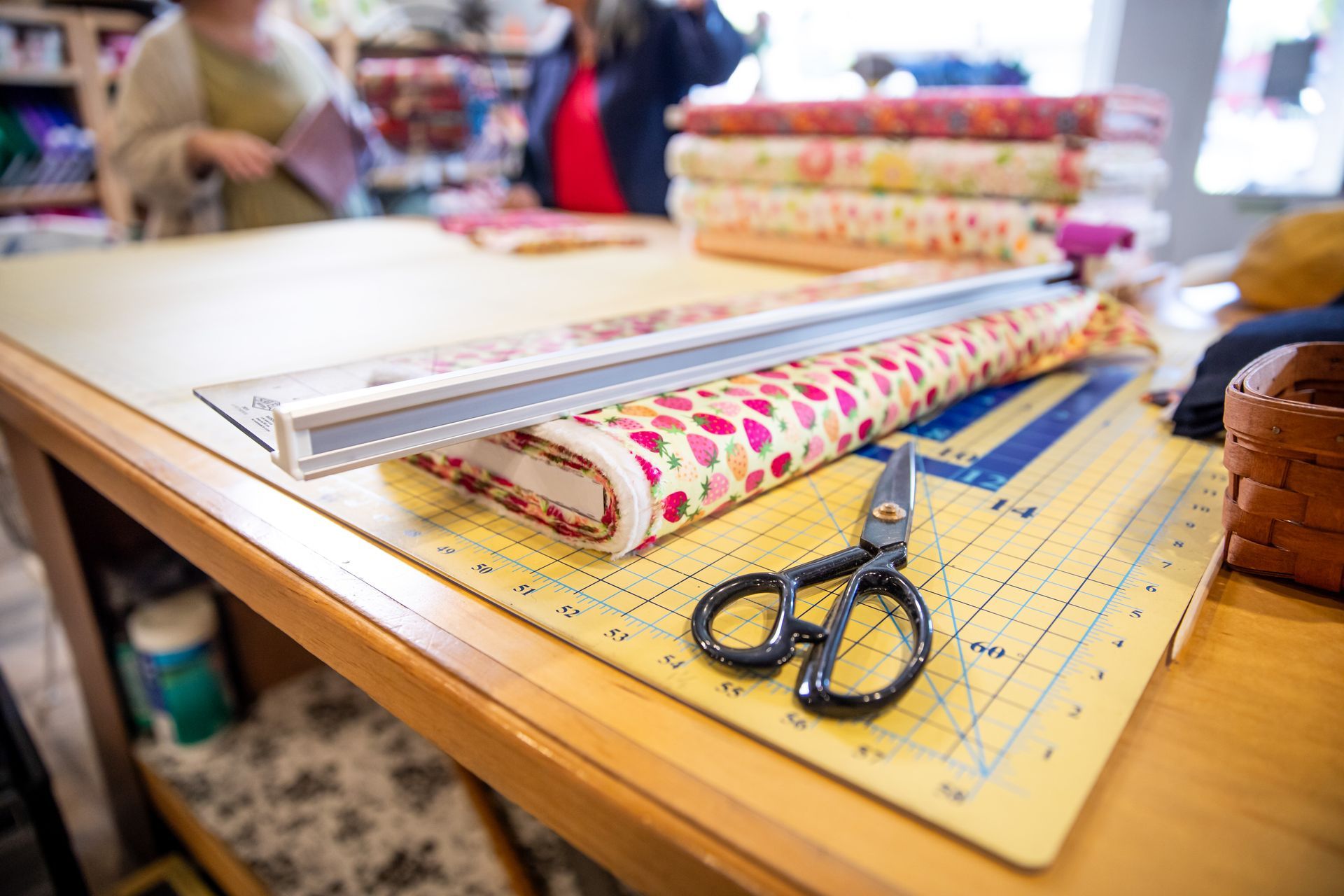 A pair of scissors sitting on top of a cutting mat on a table.