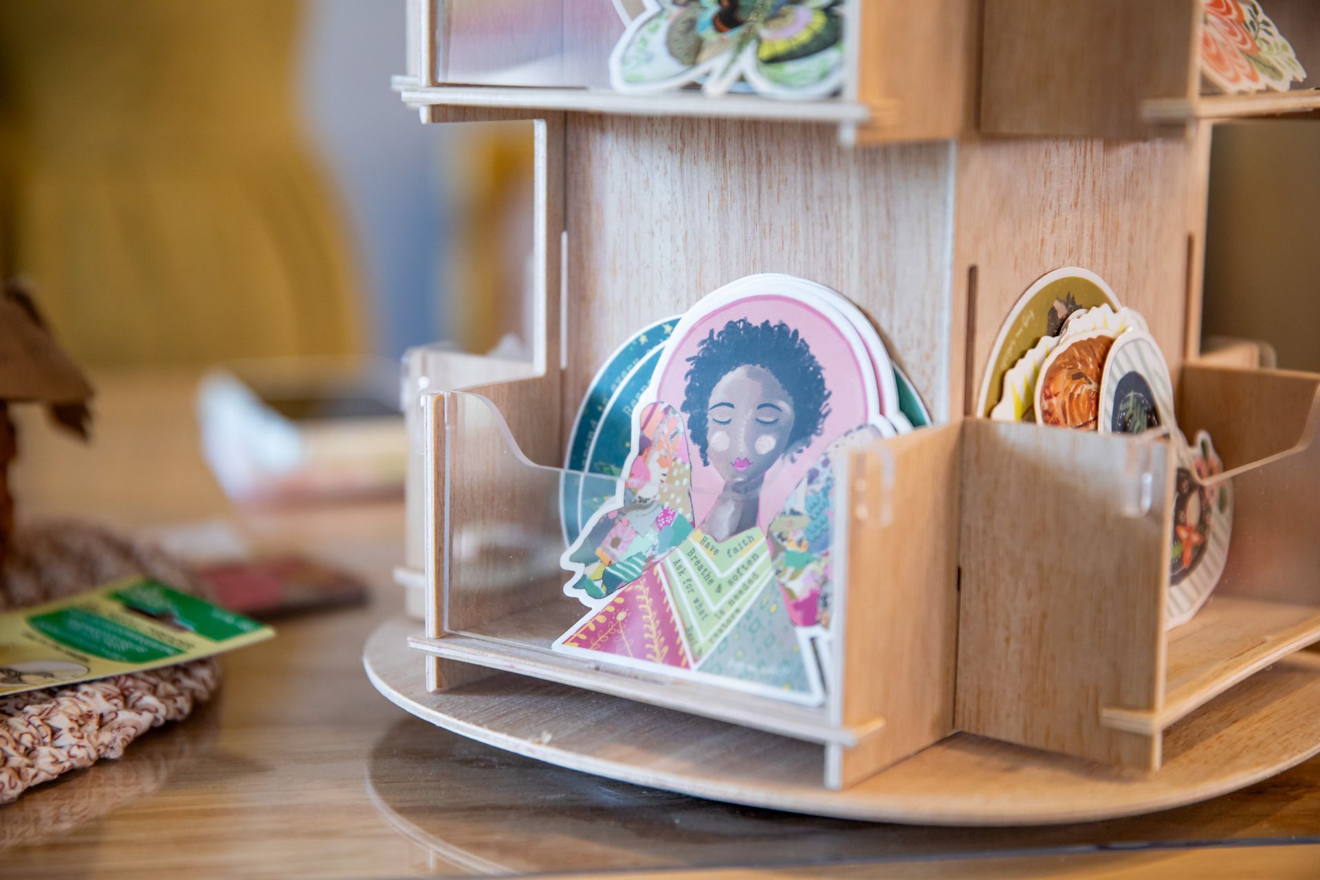 A wooden stand with stickers on it is sitting on a table.