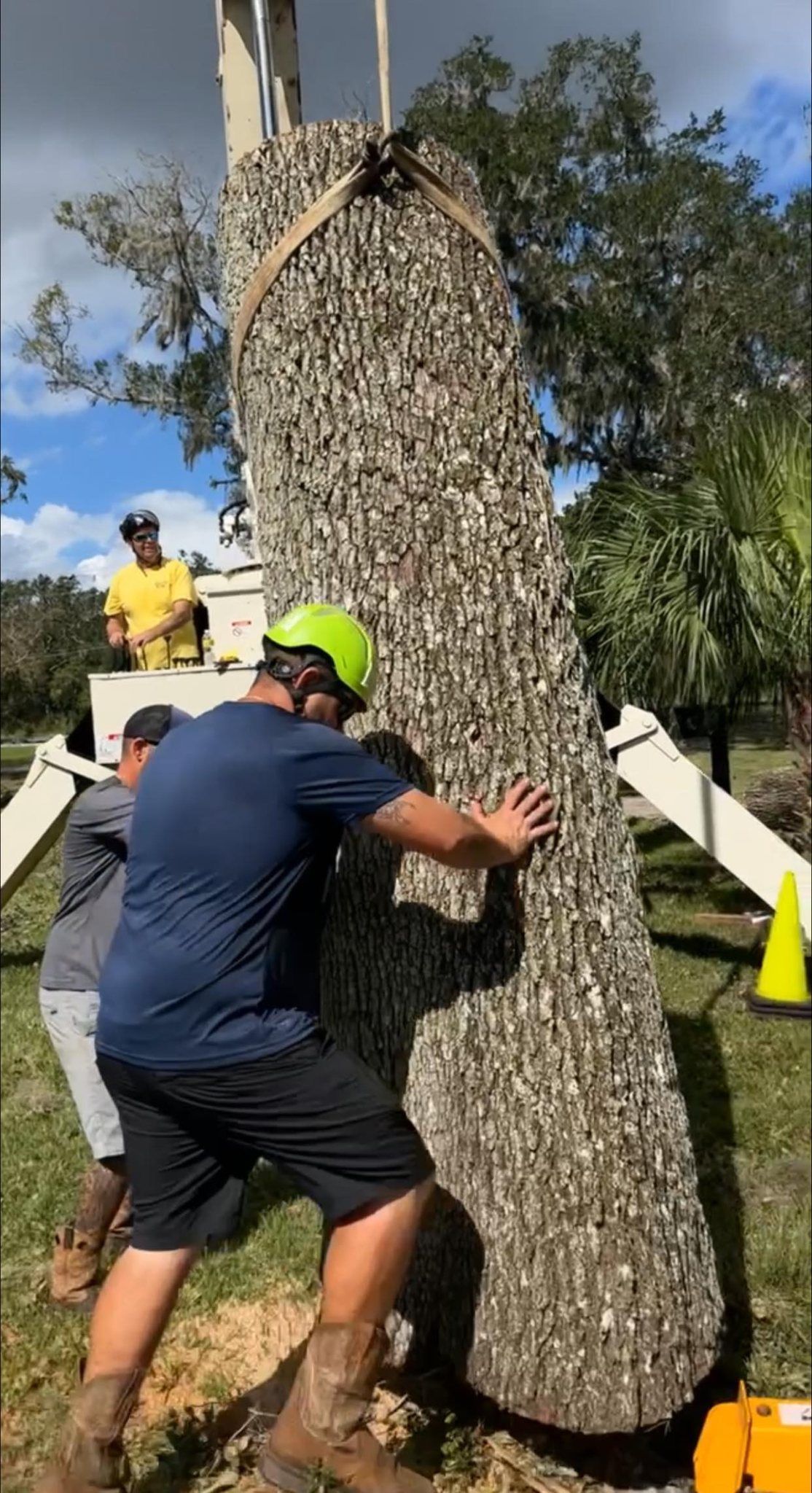 A man is carrying a large piece of wood on his back.