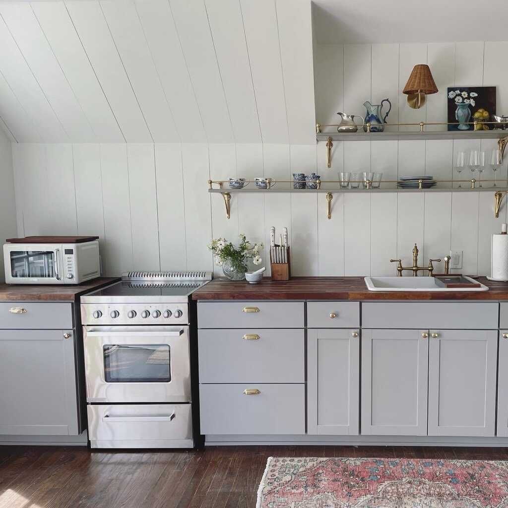 A kitchen with stainless steel appliances and gray cabinets