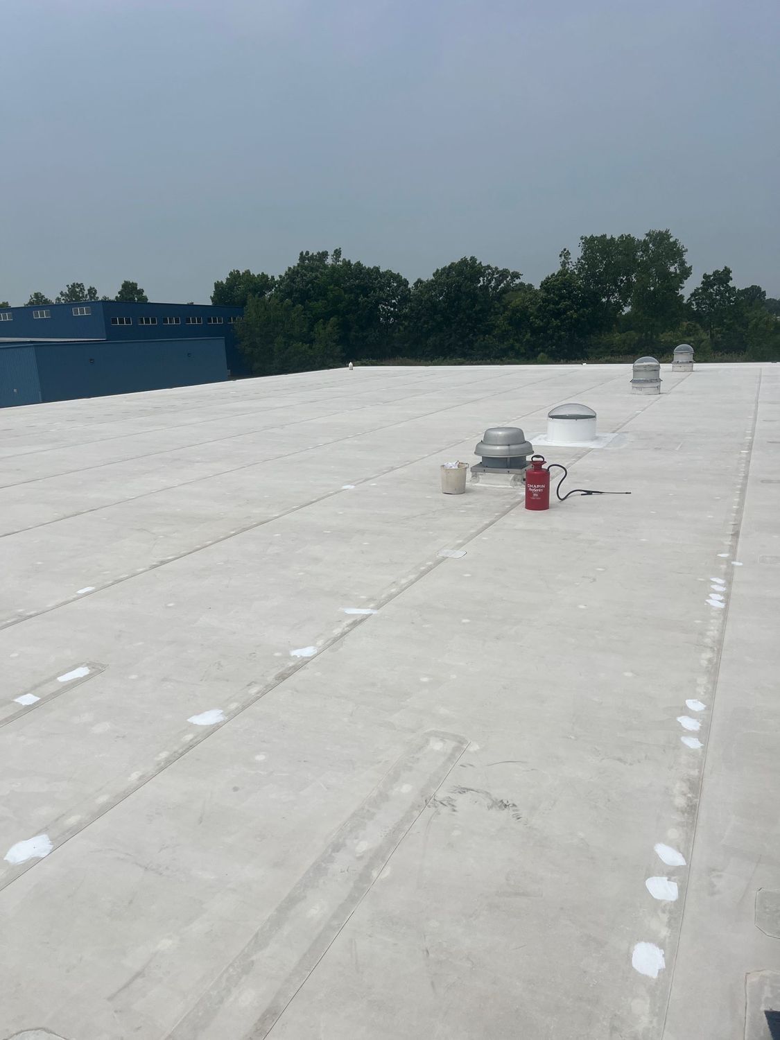 White commercial roof under construction with equipment